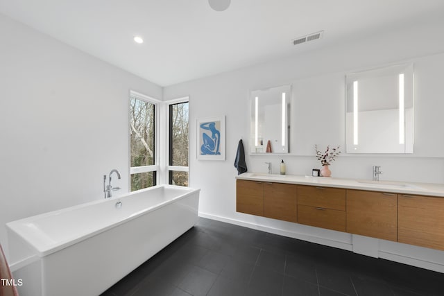 bathroom featuring vanity, a bathtub, and tile patterned floors