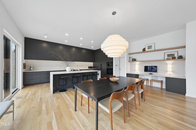 dining space with sink and light hardwood / wood-style floors