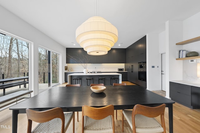 dining space featuring sink and light hardwood / wood-style flooring