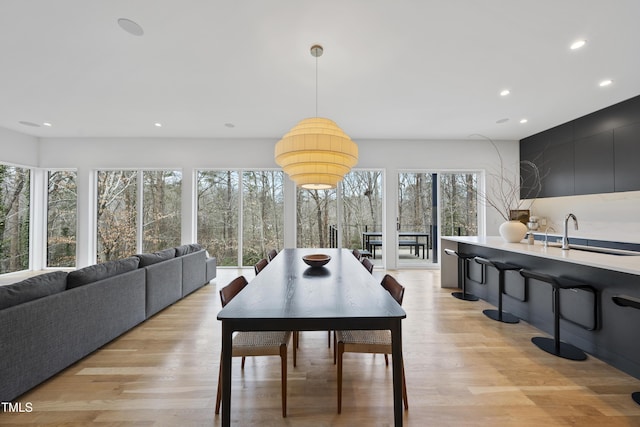 dining room with sink and light wood-type flooring