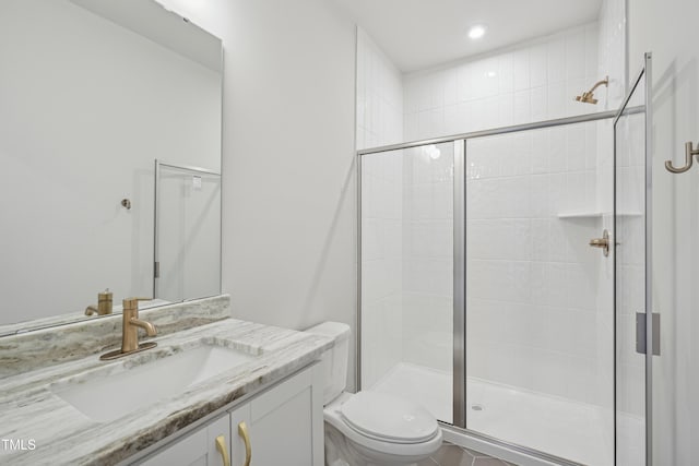 bathroom featuring toilet, a shower with door, and vanity