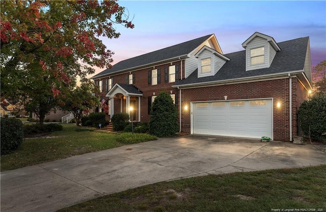 view of front of property featuring a garage and a lawn