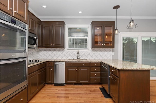 kitchen featuring pendant lighting, black electric stovetop, double wall oven, sink, and light stone countertops