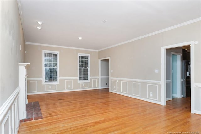 unfurnished room with a fireplace, light wood-type flooring, and ornamental molding