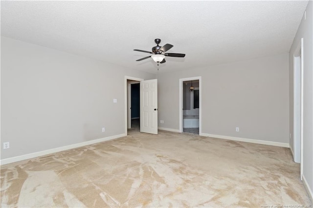 unfurnished bedroom featuring a textured ceiling, ceiling fan, light carpet, and connected bathroom