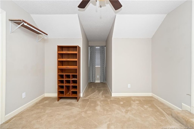 walk in closet featuring ceiling fan, light colored carpet, and lofted ceiling