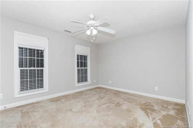 carpeted spare room featuring ceiling fan