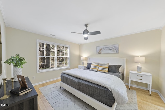 bedroom featuring ceiling fan, ornamental molding, and light wood-type flooring