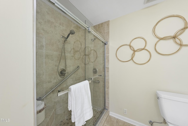 bathroom with tile patterned floors, toilet, and an enclosed shower