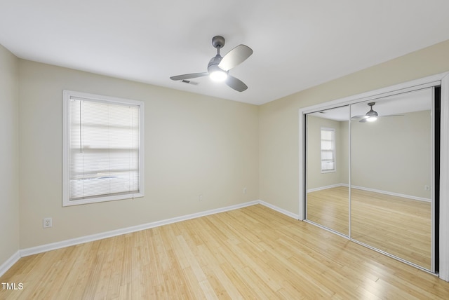 unfurnished bedroom with ceiling fan, a closet, and light wood-type flooring