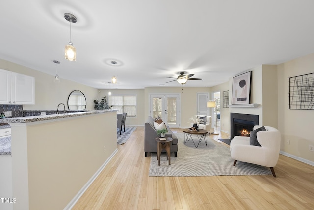 living room with ceiling fan and light hardwood / wood-style flooring