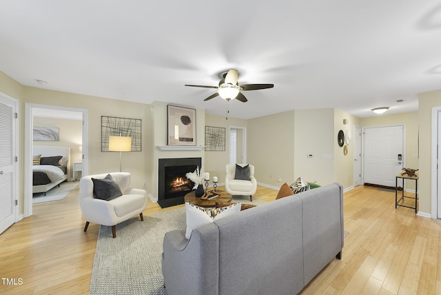 living room featuring ceiling fan and light hardwood / wood-style floors