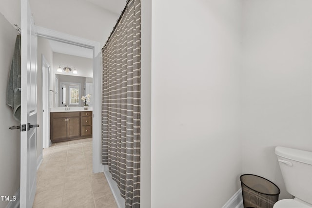 full bath featuring a shower with curtain, toilet, vanity, tile patterned flooring, and baseboards