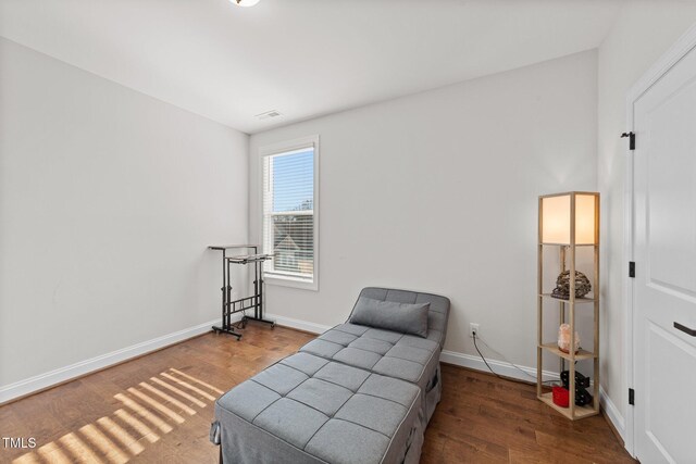 sitting room featuring wood finished floors, visible vents, and baseboards