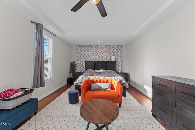 bedroom with ceiling fan, baseboards, and wood finished floors