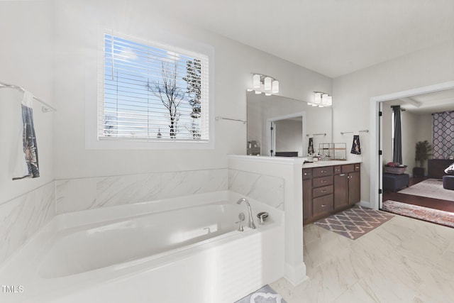 ensuite bathroom featuring a garden tub, connected bathroom, and vanity