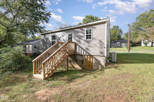 rear view of property featuring a yard and central AC