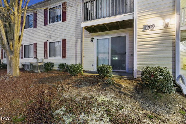 view of exterior entry with a balcony and cooling unit