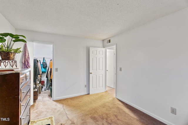 carpeted bedroom featuring a textured ceiling and a spacious closet