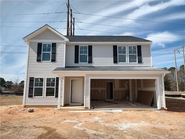 view of front of home with a garage and roof with shingles