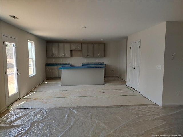 kitchen with dark countertops, visible vents, and a center island