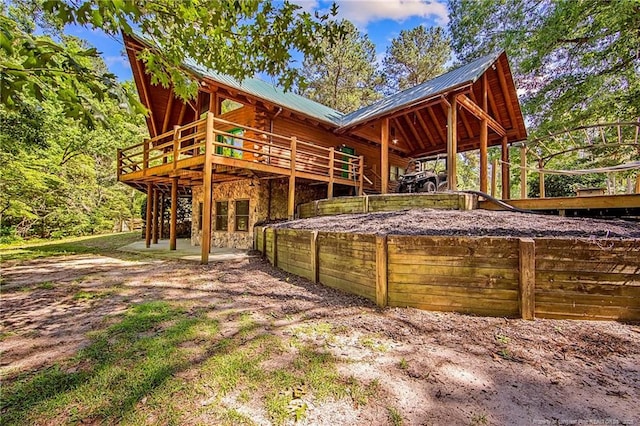 329 Silver Grove Church Rd, Rockingham, NC 28379 - rear view of house featuring log exterior, metal roof, and a deck