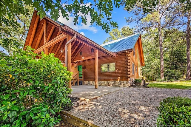 329 Silver Grove Church Rd, Rockingham, NC 28379 - view of property exterior with metal roof, log exterior, and a patio area
