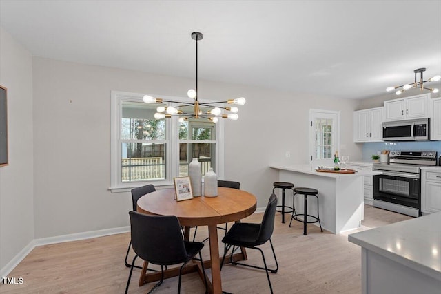 dining room with a healthy amount of sunlight, a chandelier, and light hardwood / wood-style floors