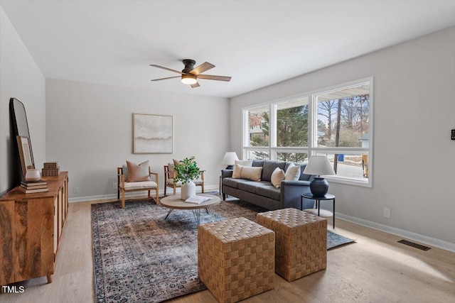 living room with light hardwood / wood-style flooring and ceiling fan