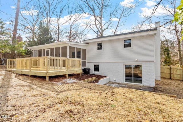 back of house featuring a yard, a sunroom, and a deck