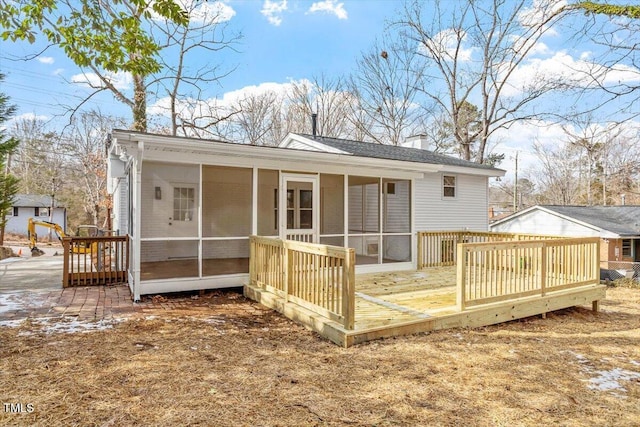 back of property with a wooden deck and a sunroom