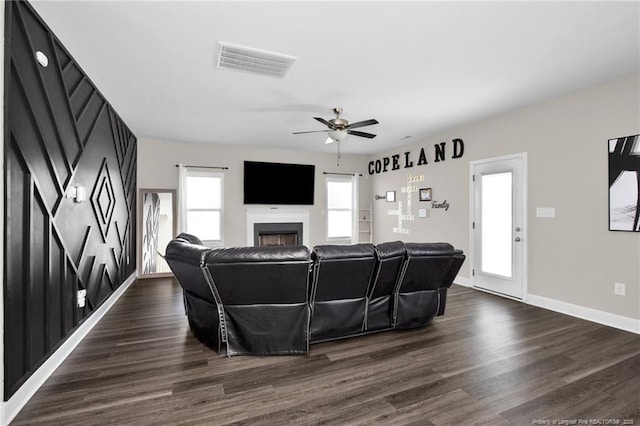 living room featuring ceiling fan and dark hardwood / wood-style flooring