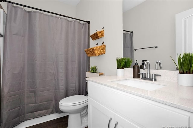 bathroom with hardwood / wood-style floors, vanity, and toilet