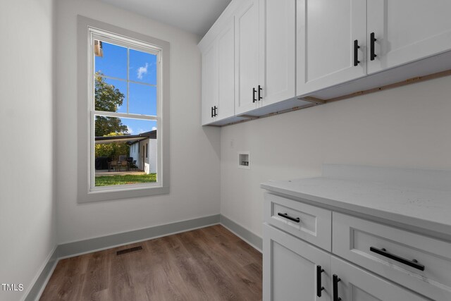 laundry room featuring cabinets, light wood-type flooring, and hookup for a washing machine