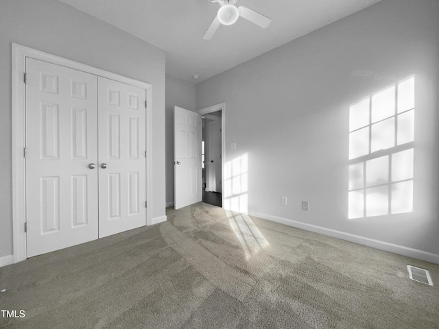 unfurnished bedroom with carpet, ceiling fan, and a closet