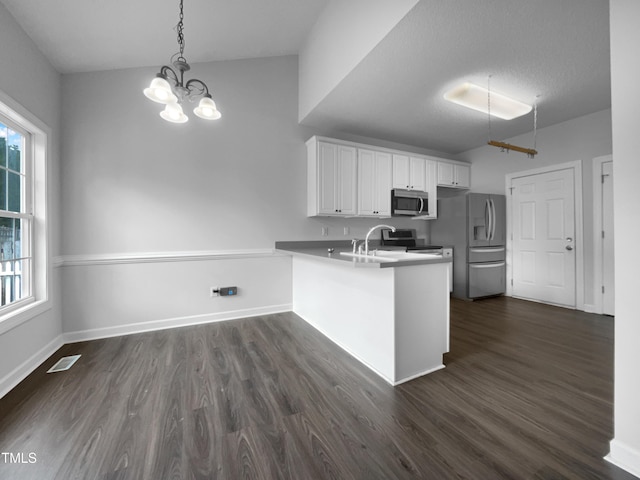 kitchen featuring kitchen peninsula, a chandelier, decorative light fixtures, white cabinets, and appliances with stainless steel finishes