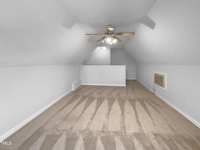 additional living space featuring a textured ceiling, light colored carpet, ceiling fan, and lofted ceiling