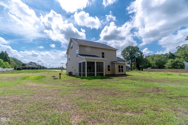 back of property featuring a sunroom, a yard, and central AC unit