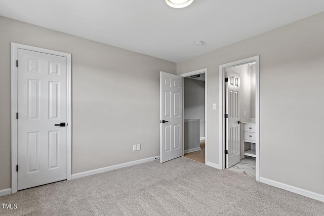 unfurnished bedroom with light colored carpet and connected bathroom