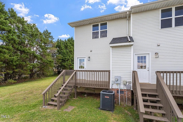 back of property featuring central AC unit, a deck, and a lawn