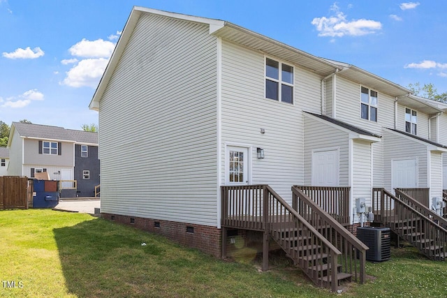 rear view of house featuring central air condition unit, a yard, and a deck