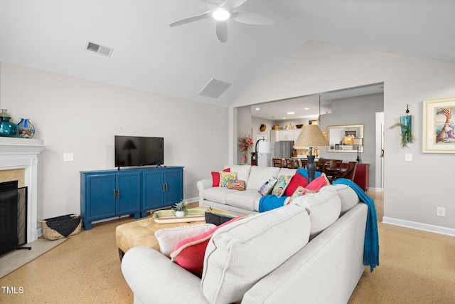 living room featuring ceiling fan, a fireplace, and vaulted ceiling