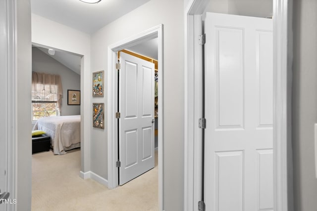 hallway with light carpet and lofted ceiling