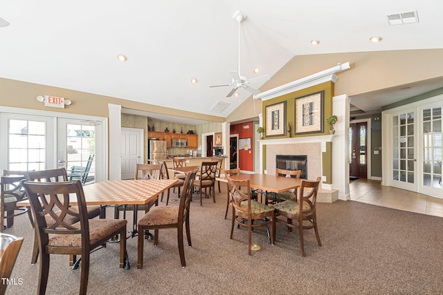 dining area with ceiling fan, french doors, light tile patterned floors, and lofted ceiling