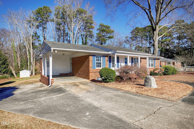 single story home featuring a carport and a storage shed