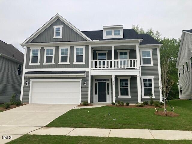 craftsman-style home featuring a garage, a front yard, driveway, and a balcony