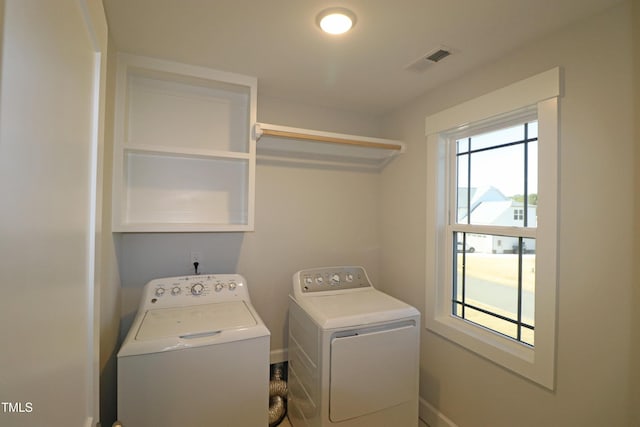 clothes washing area featuring cabinets and separate washer and dryer