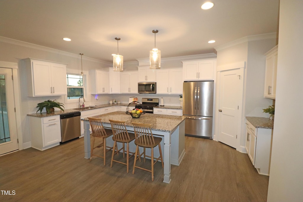 kitchen with white cabinets, sink, a kitchen island, and stainless steel appliances