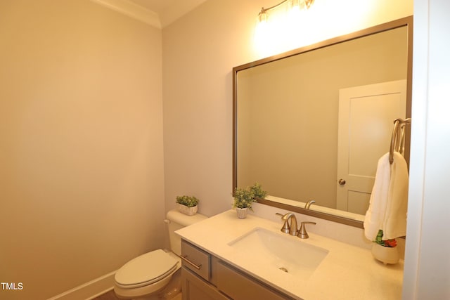 bathroom with vanity, ornamental molding, and toilet