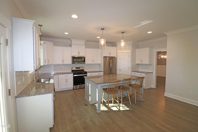 kitchen featuring white cabinetry, decorative backsplash, a center island, and appliances with stainless steel finishes